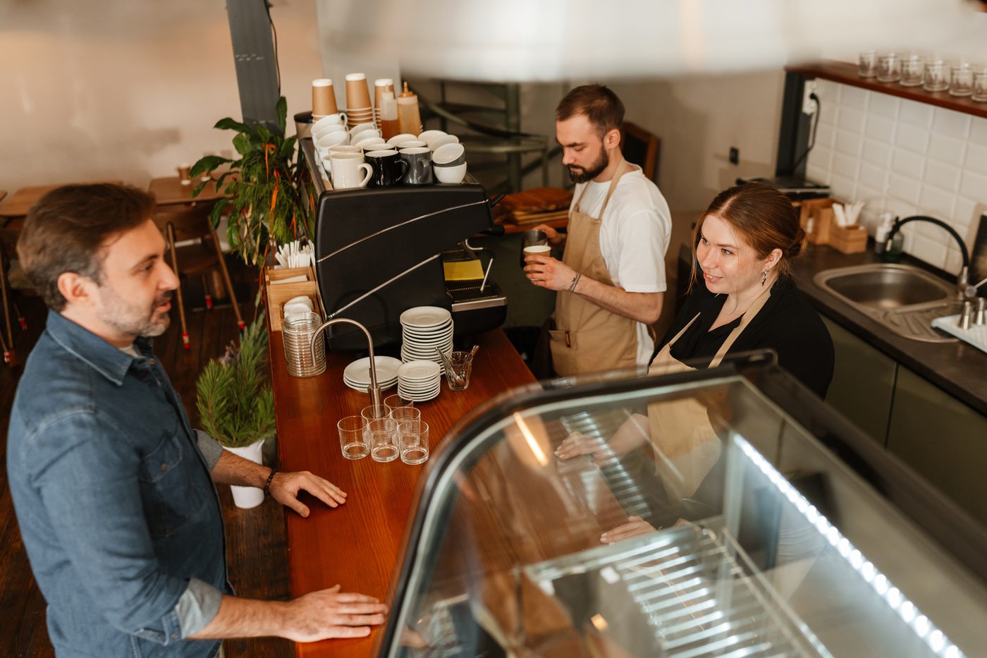 Barista atendiendo a un cliente en una cafetería